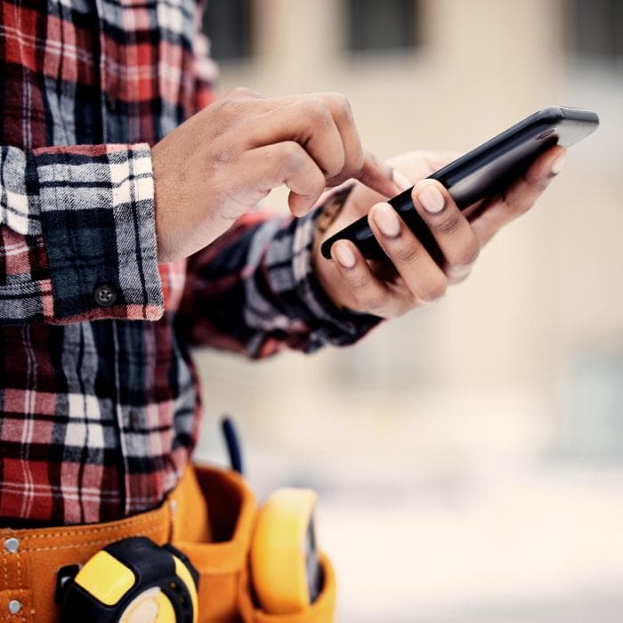 Hände mit iPhone, Zollstock am Gürtel